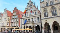 Am Prinzipalmarkt von Münster steht das beflaggte Stadtweinhaus von 1615, rechts daneben das Rathaus