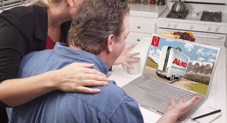 Couple In Kitchen Using Laptop with Blank Screen. Screen can be easily used for your own message or picture using the included clipping path.
