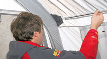 DWT stabilisiert das Zelt an der Dachkante mit einem Metallstab.
