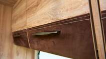 Das Chalet-Mobil bietet viele besondere Details – Schrankklappen mit Leder, gestickte Vorhangbordüren.