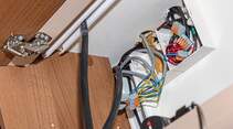 Eine Verteilerdose befindet sich im Hängeschrank. Die Kabel verlaufen unsichtbar hinter dem Schrank.