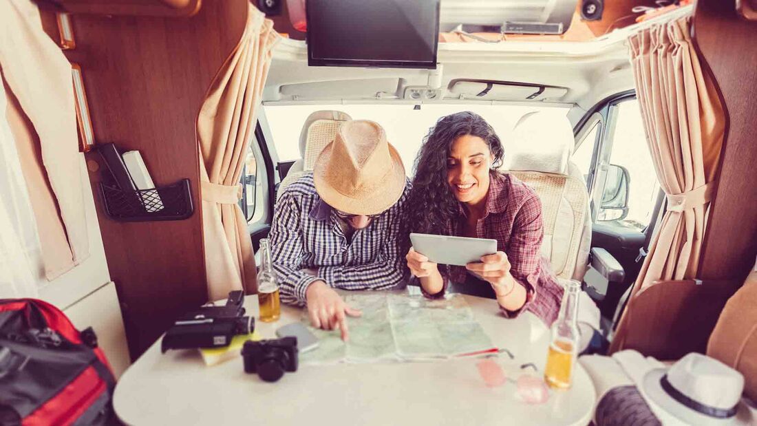 Mid adult couple planning road trip in campervan