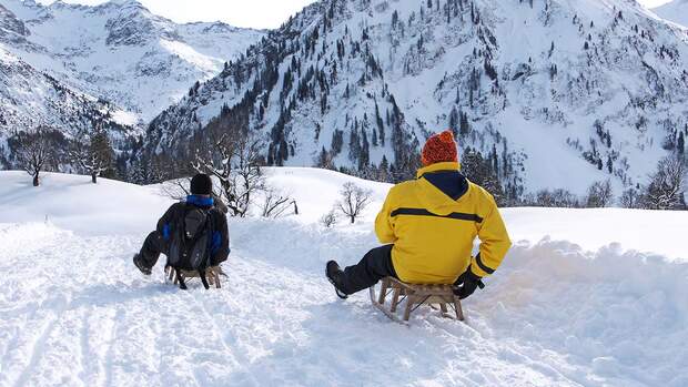 Schlittenpartie auf einer Naturrodelbahn bei Bad Hindelang in den Allgäuer Alpen