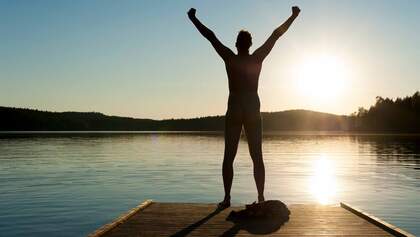 A man stretches his arms on a jetty